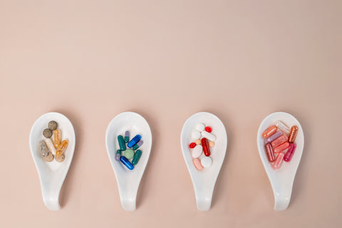 A row of spoons filled with different types of pills